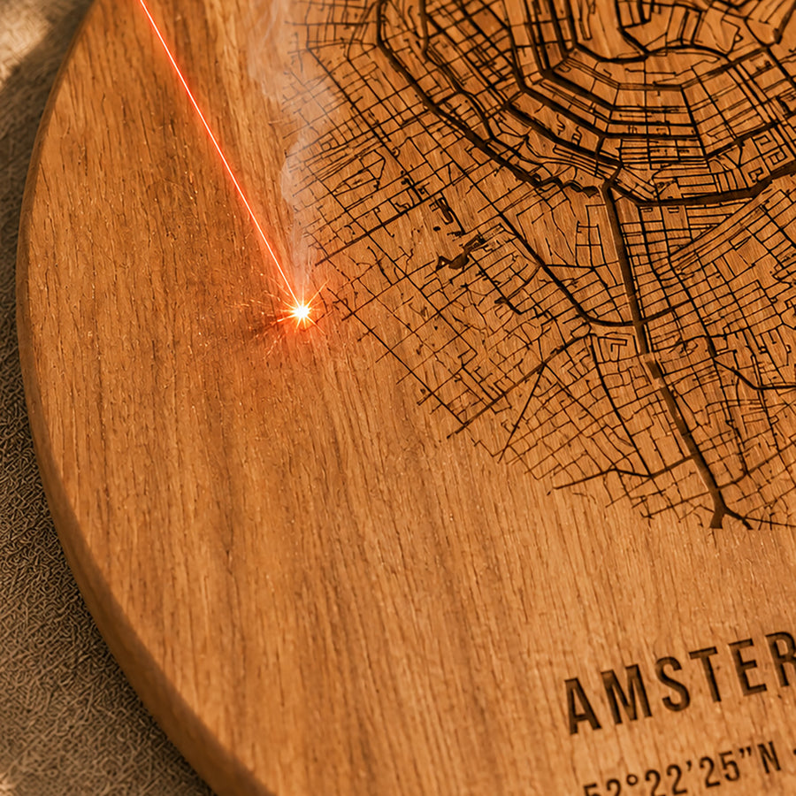 Laser graveert een plattegrond in een houten plank, met zichtbare vonk en rookpluim