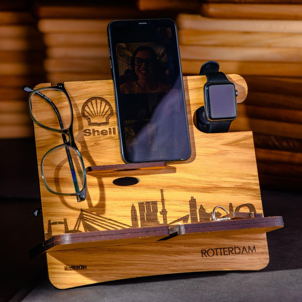 Houten telefoonhouder met het Shell-logo en de skyline van Rotterdam gegraveerd